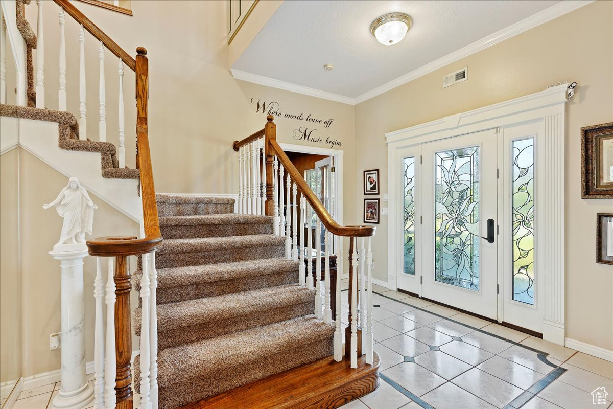 Entryway with crown molding and tile patterned flooring