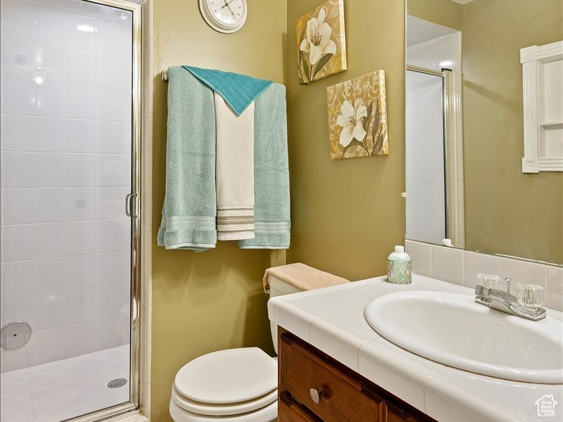 Bathroom with tile patterned flooring, walk in shower, a textured ceiling, toilet, and vanity