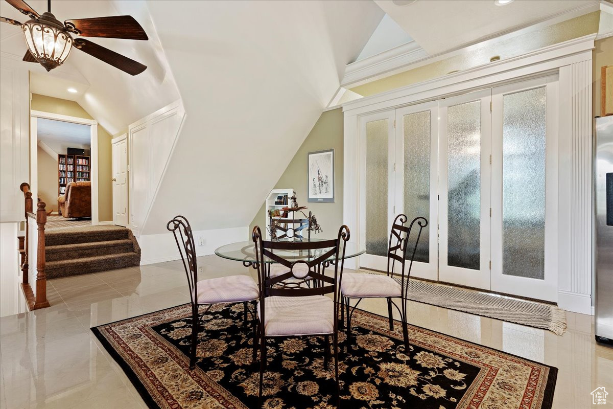 Dining area with ornamental molding, ceiling fan, vaulted ceiling, and light tile patterned floors