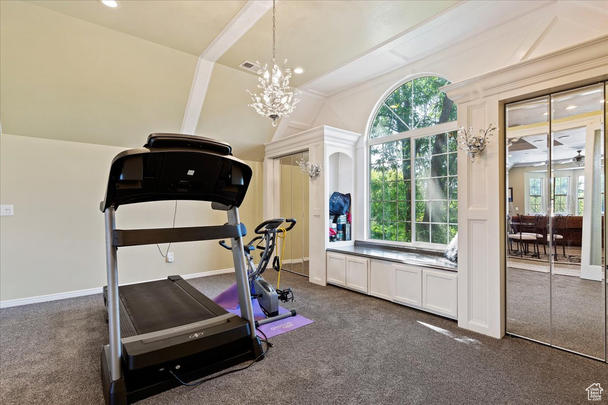 Bedroom with a notable chandelier, dark colored carpet, plenty of natural light, and vaulted ceiling