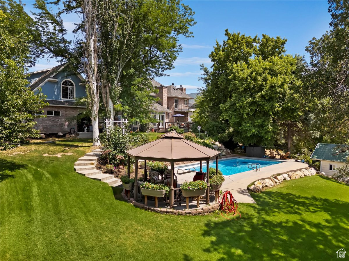 View of swimming pool featuring a gazebo and a lawn