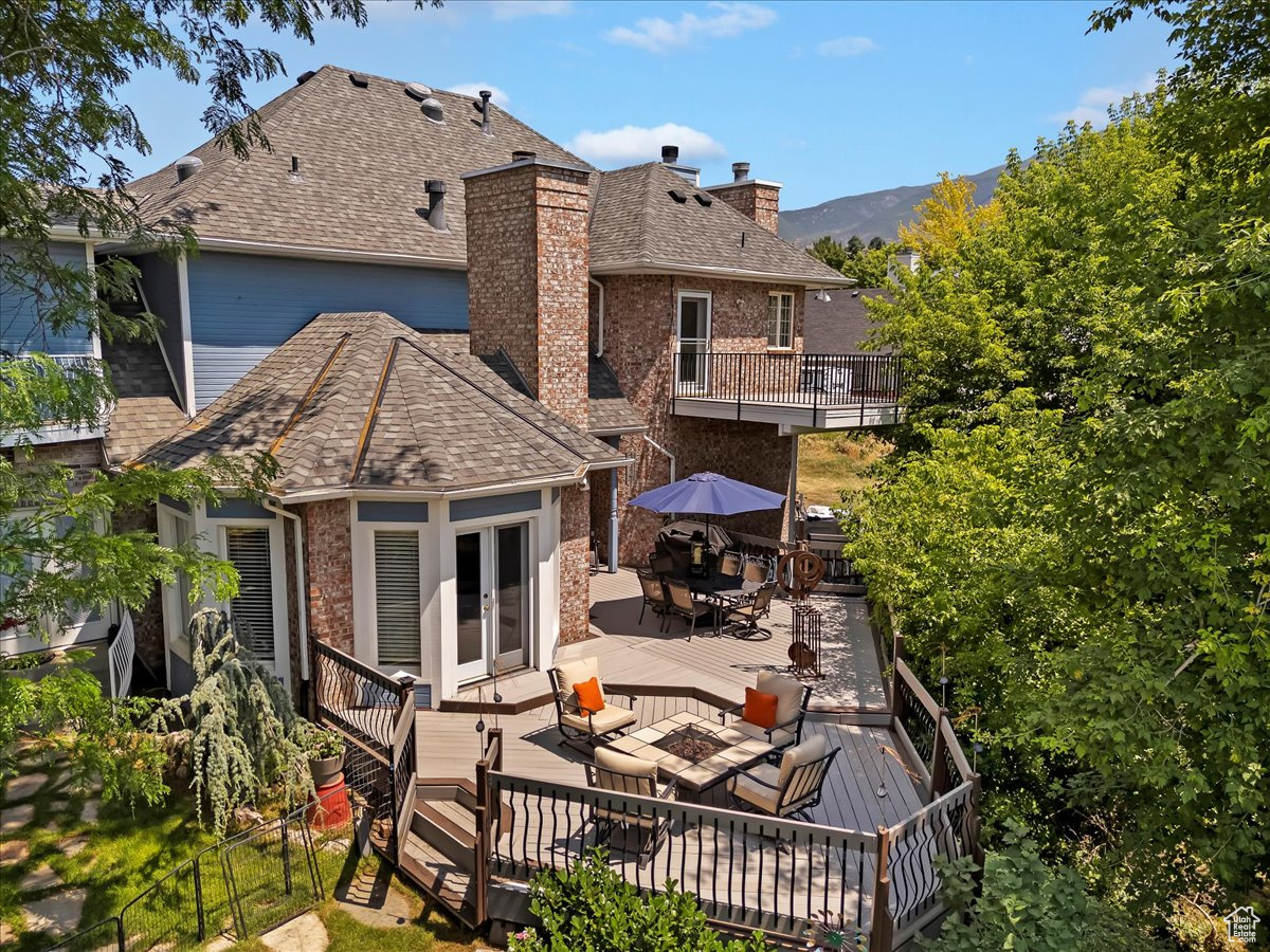 Rear view of house featuring an outdoor living space and a deck