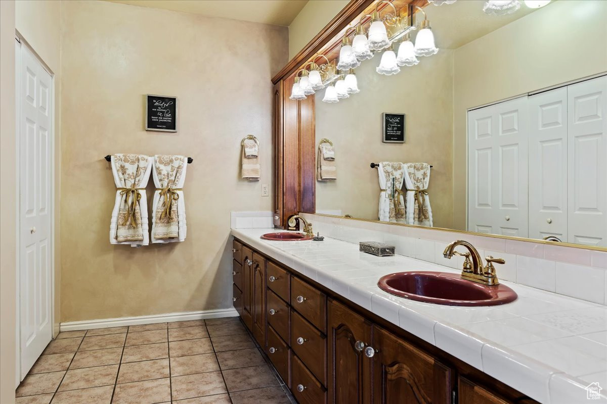 Bathroom featuring tile patterned flooring and dual bowl vanity