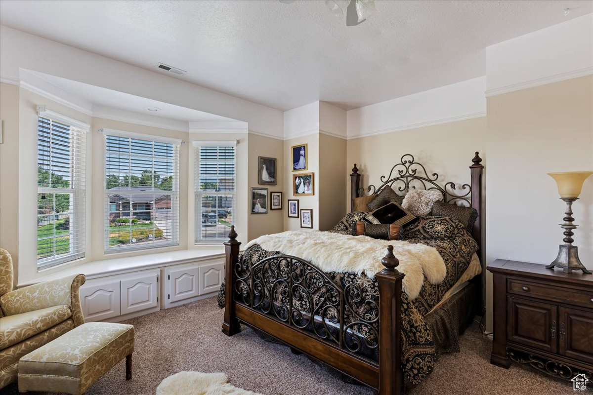 Carpeted bedroom featuring crown molding