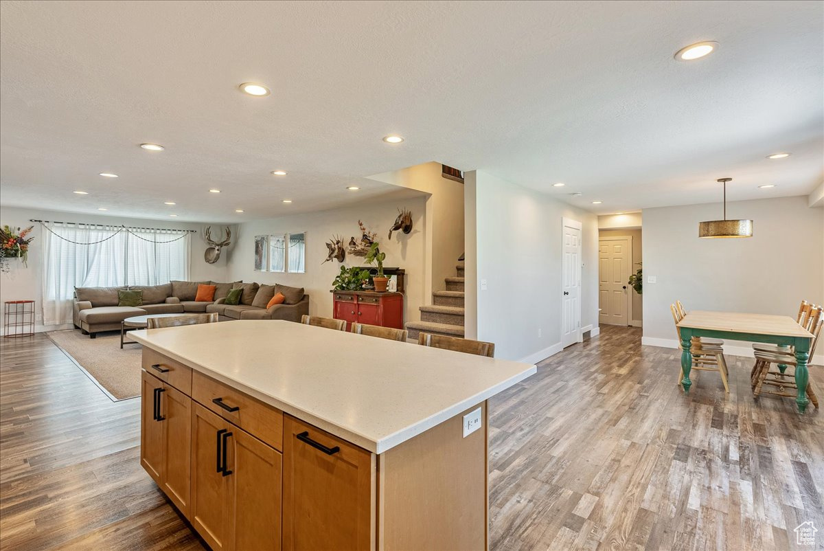 Kitchen with decorative light fixtures, a center island, and light wood-type flooring