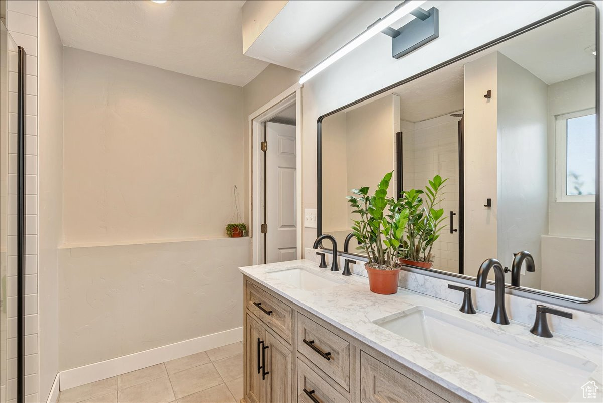 Bathroom featuring tile patterned flooring and dual bowl vanity