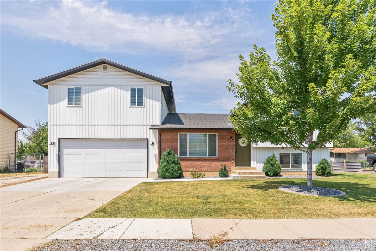 Split level home with a garage and a front yard