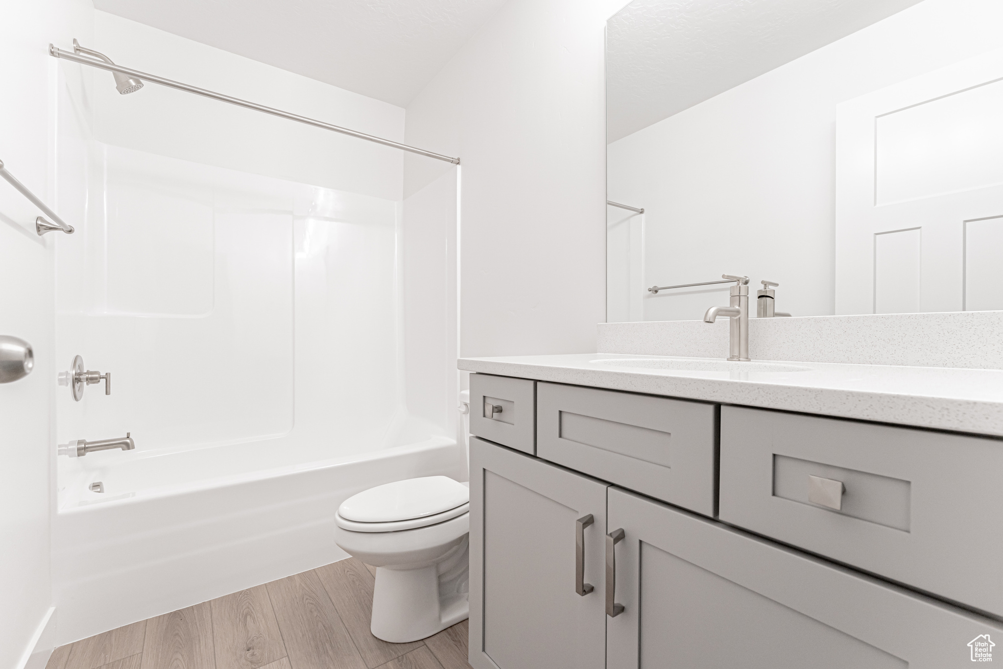 Full bathroom featuring vanity,  shower combination, hardwood / wood-style flooring, and toilet