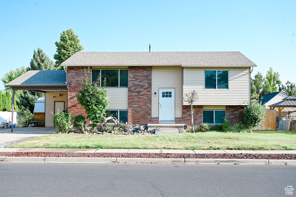 Bi-level home featuring a carport and a front lawn