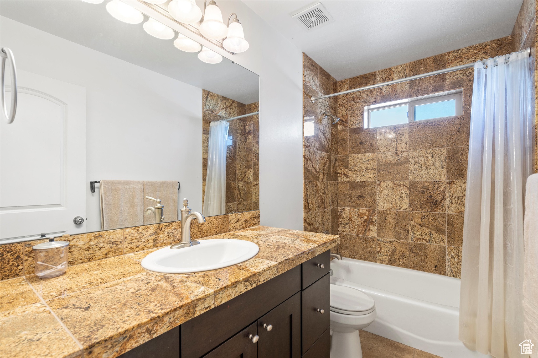 Full bathroom with toilet, shower / bathtub combination with curtain, and vanity