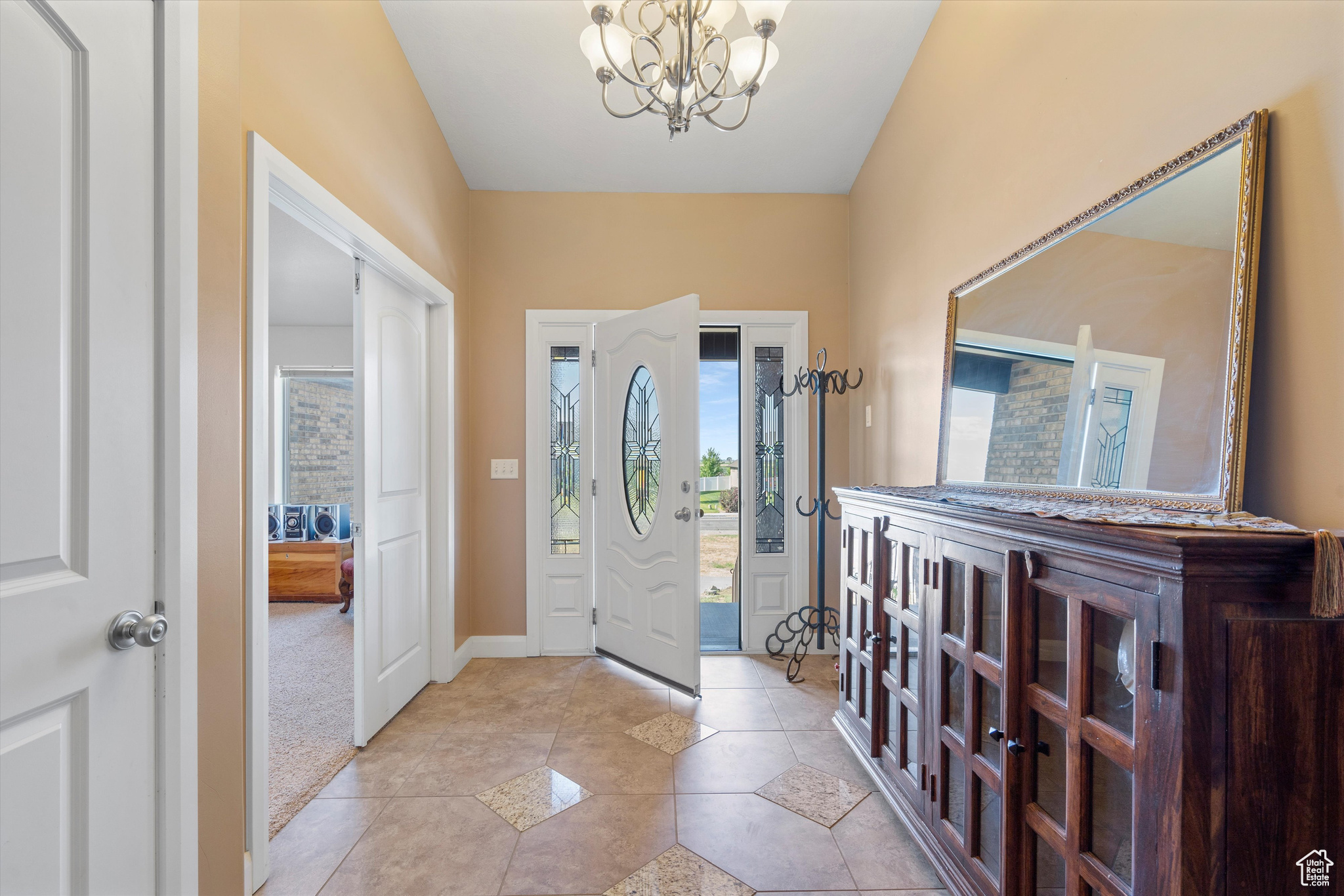 Foyer entrance featuring a notable chandelier and light tile patterned floors