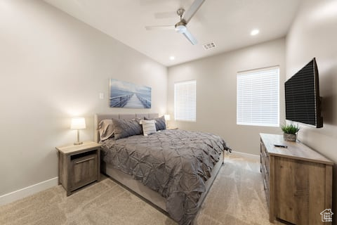 Bedroom with ceiling fan and light colored carpet