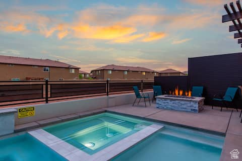 Pool at dusk with a fire pit, an in ground hot tub, and a patio