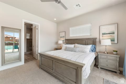 Carpeted bedroom with ceiling fan and access to exterior