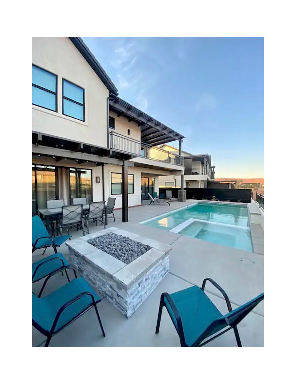 Pool at dusk featuring a patio area and a fire pit