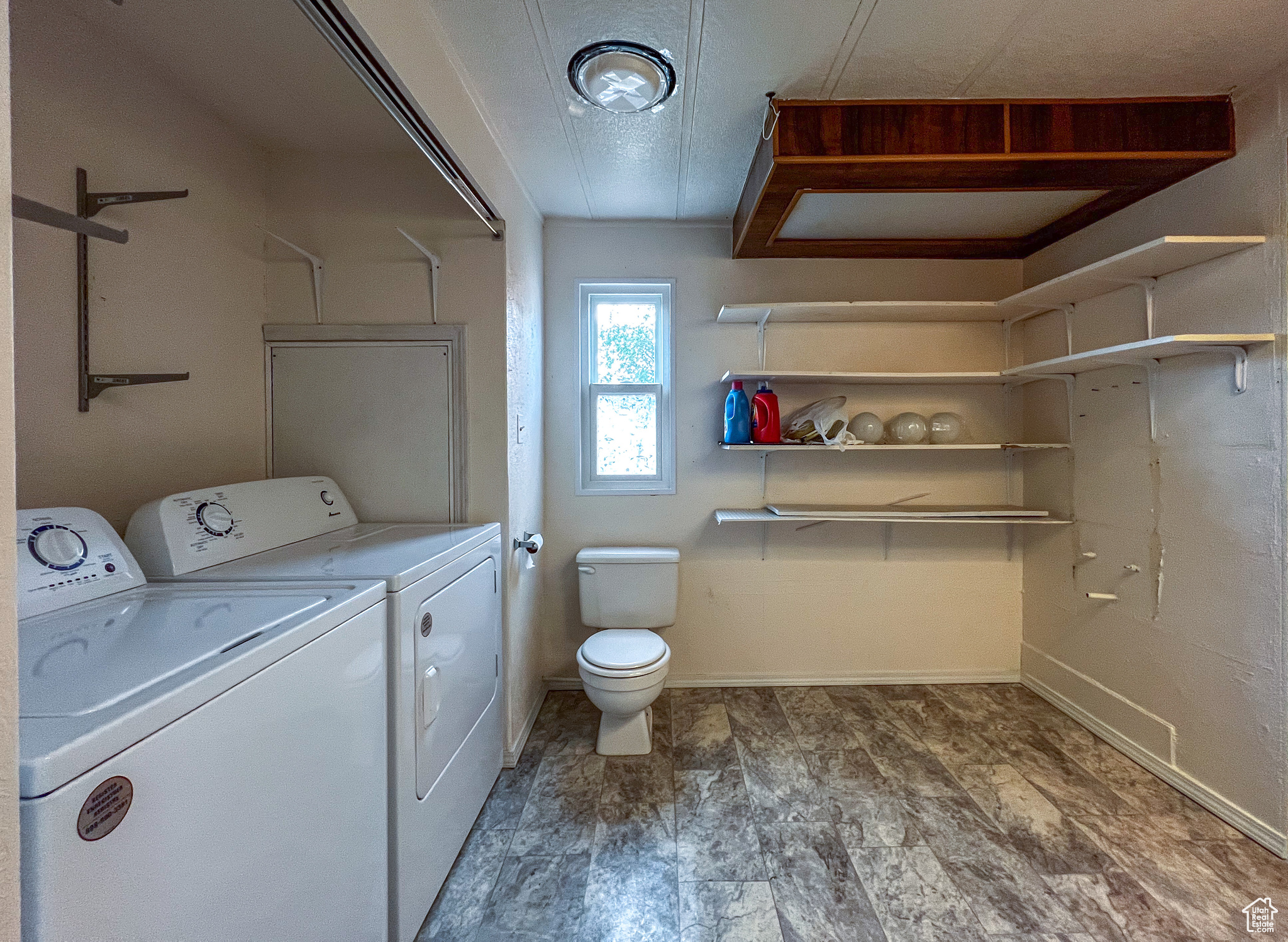 Clothes washing area with washing machine and clothes dryer and tile patterned floors