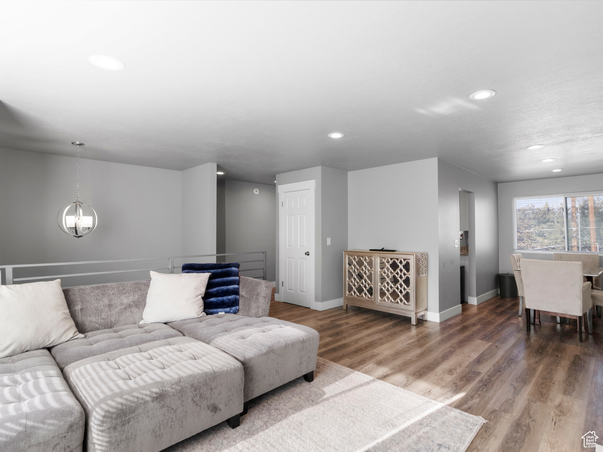 Living room with a notable chandelier and hardwood / wood-style floors