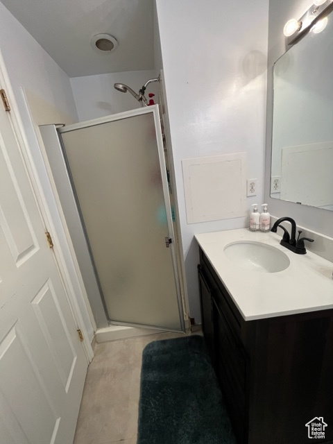 Master Bathroom featuring a shower with shower door, vanity, and tile patterned flooring