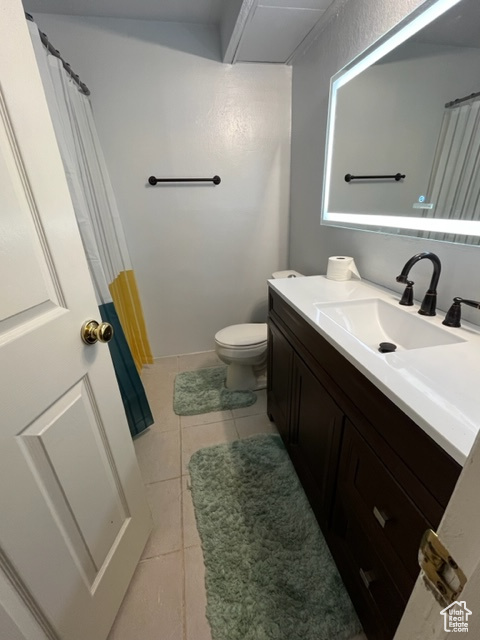 Bathroom with tile patterned floors, vanity, and toilet