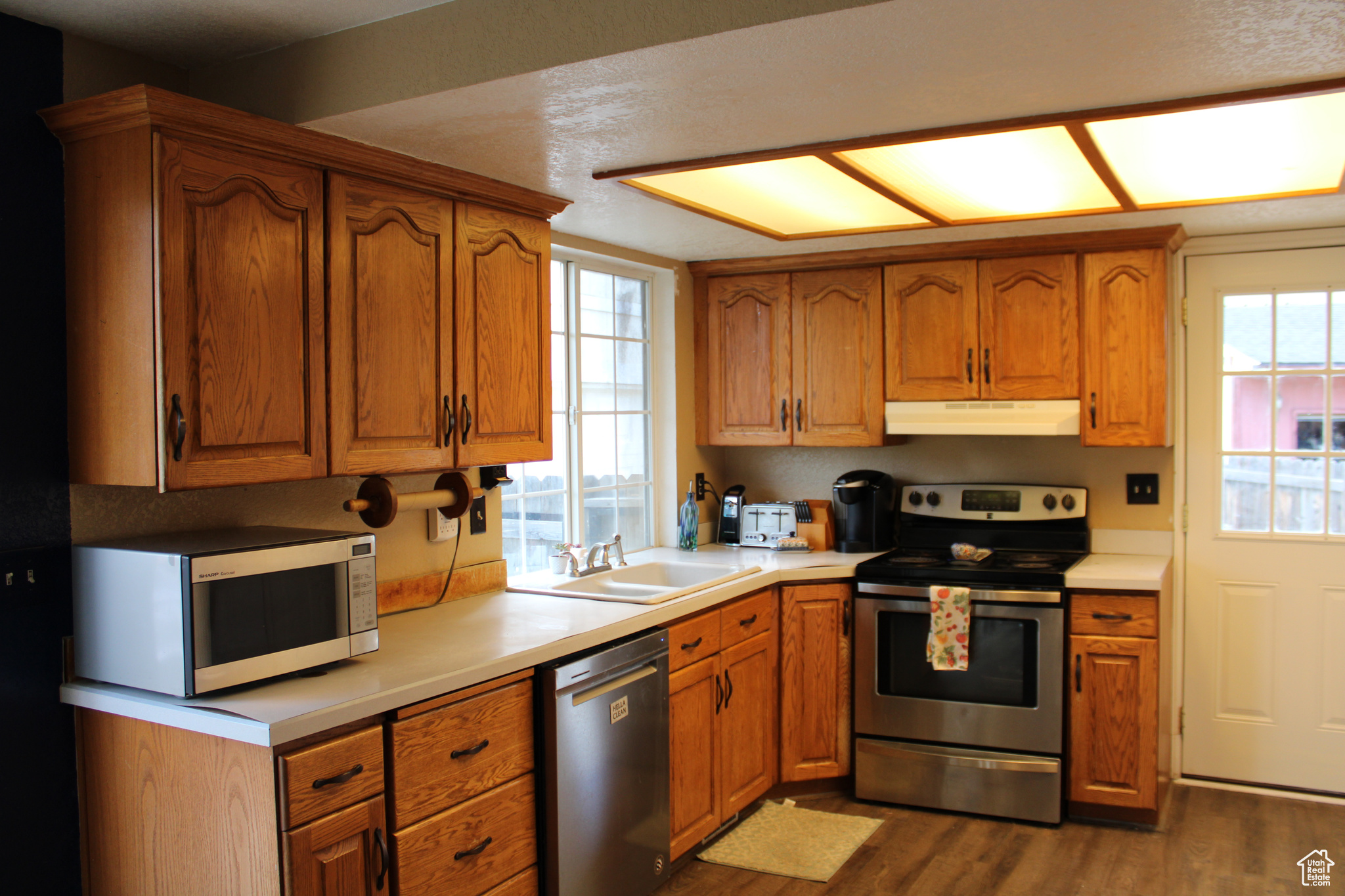 Kitchen featuring sink, laminate flooring, and stainless steel appliances.