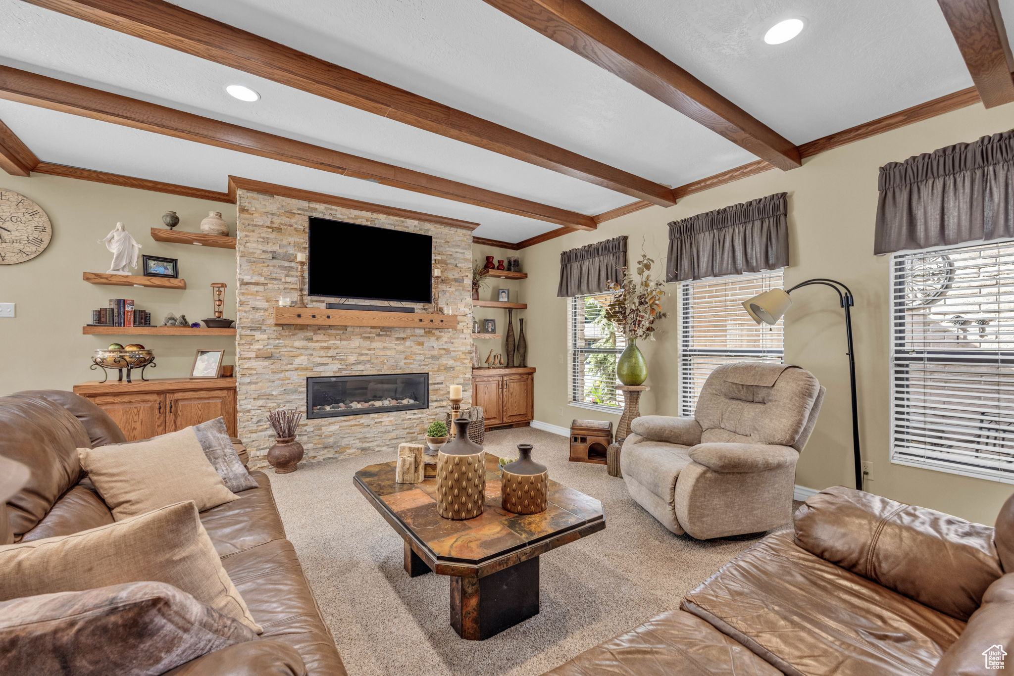 Carpeted living room with a fireplace and beamed ceiling