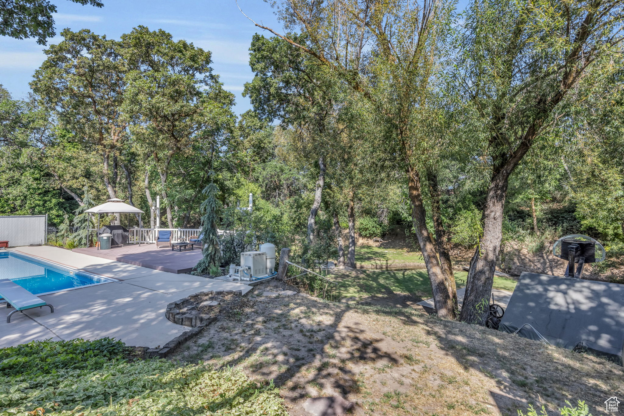 View of yard with a pool side deck and a patio area, diving board