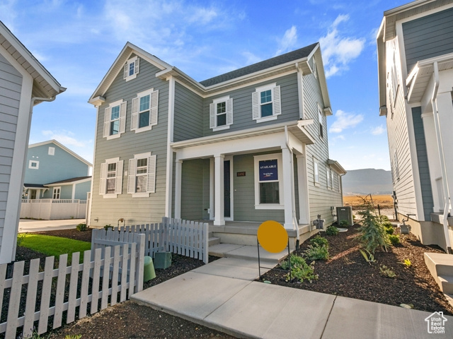 View of front of property with a porch, a mountain view, and central AC