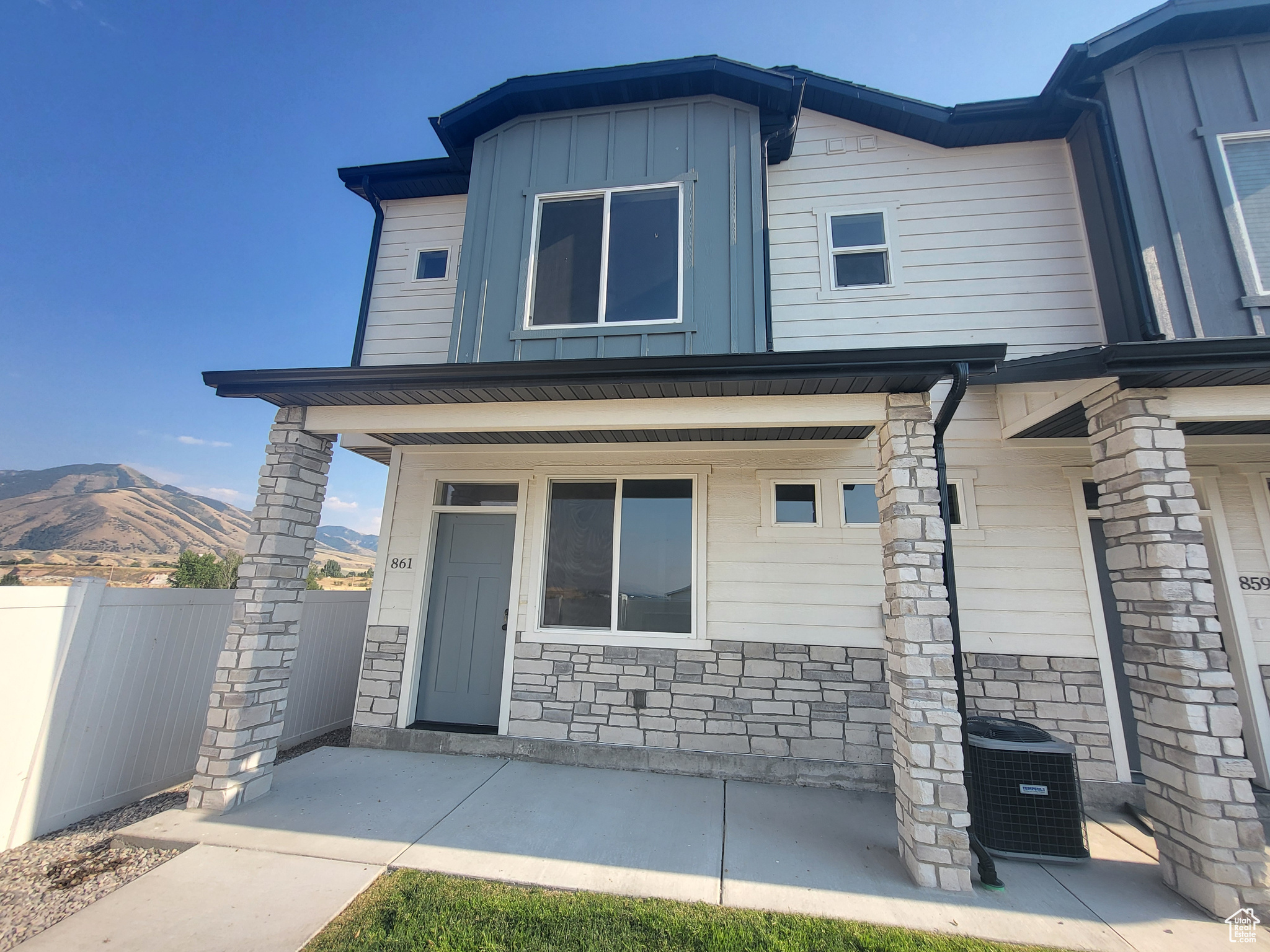 View of front of house with central AC unit, a patio area, and a mountain view