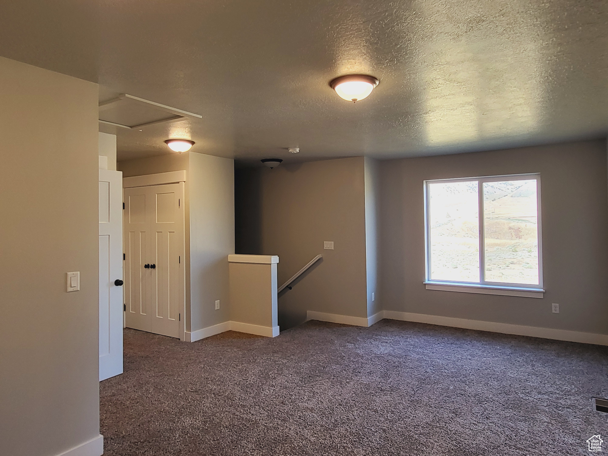 Carpeted empty room with a textured ceiling