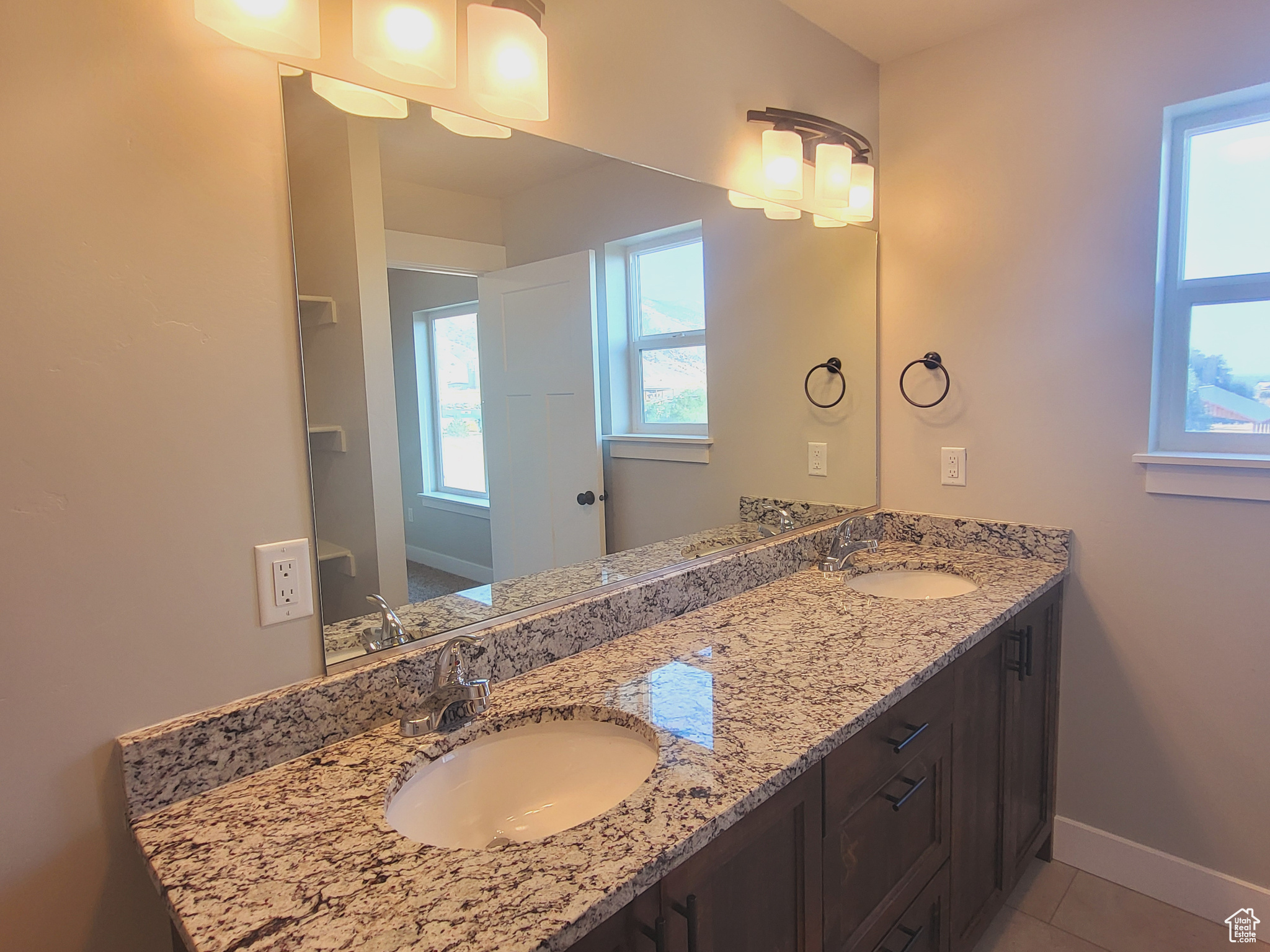 Bathroom with tile patterned floors and double sink vanity