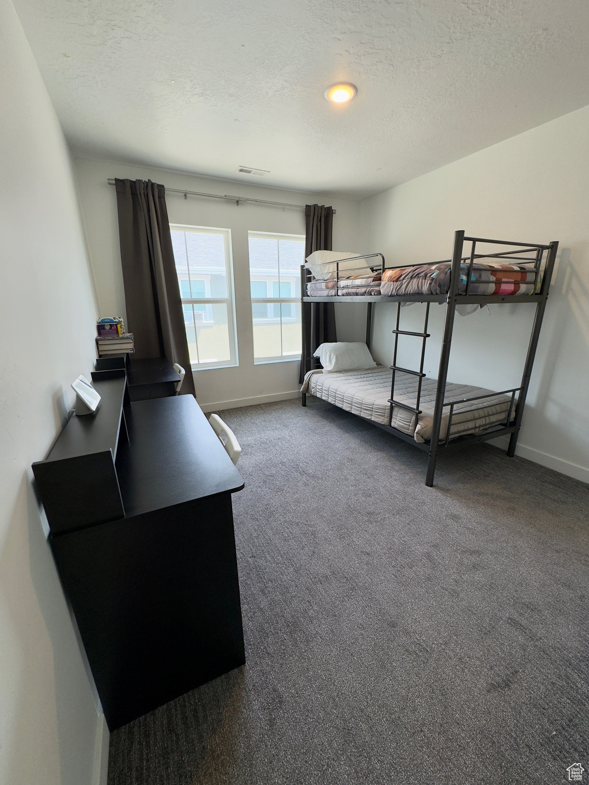 Carpeted bedroom featuring a textured ceiling