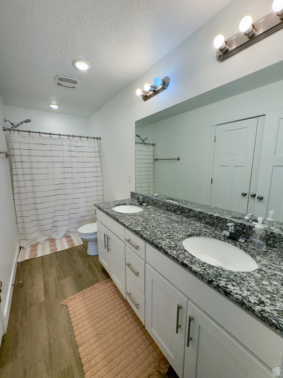 Master bathroom with granite counters, double sinks and a tub/shower combo