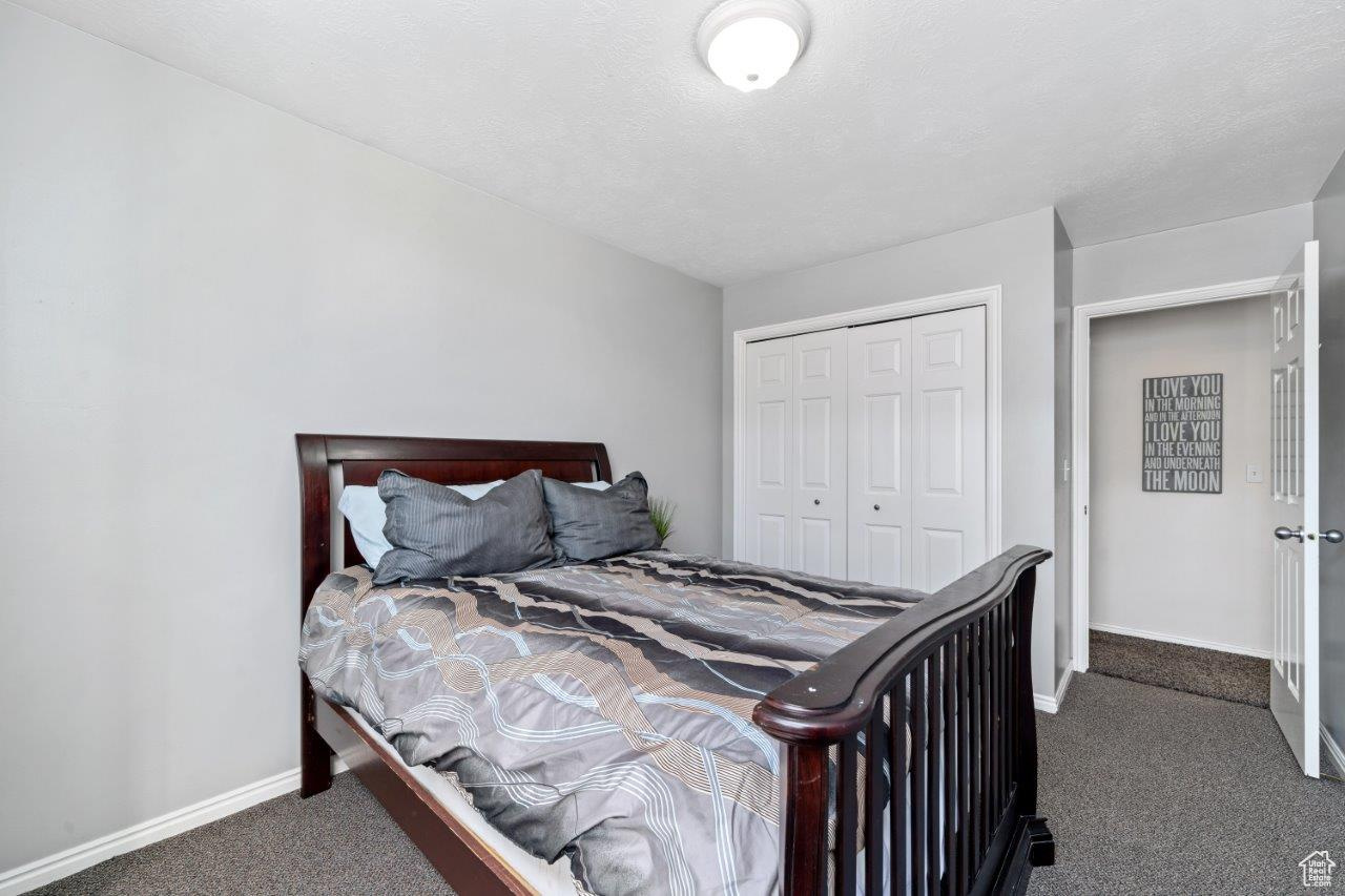 Carpeted bedroom with a closet