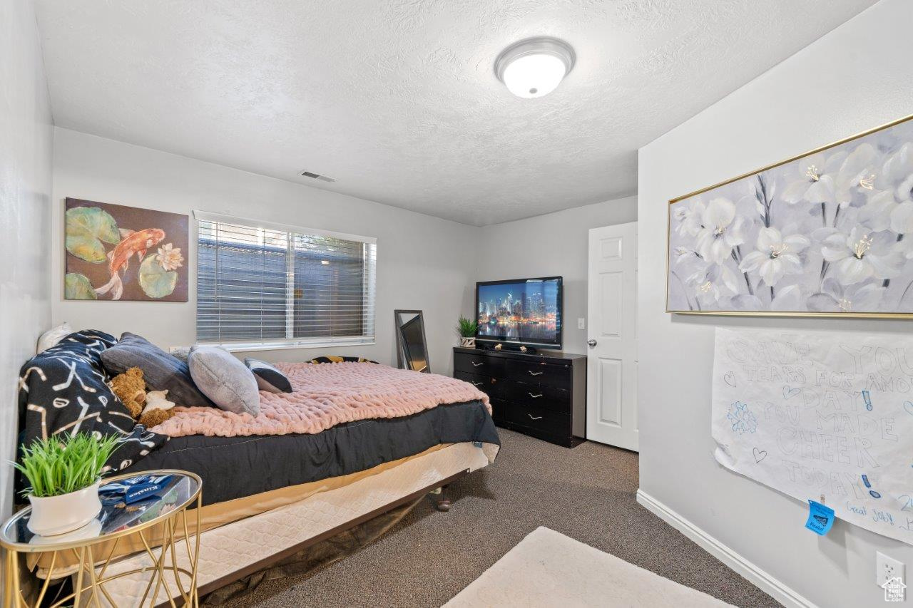 Carpeted bedroom featuring a textured ceiling