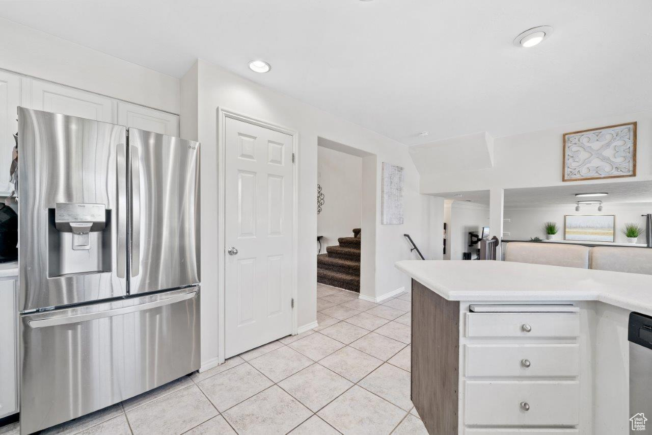 Kitchen featuring white cabinetry, appliances with stainless steel finishes, and light tile patterned floors