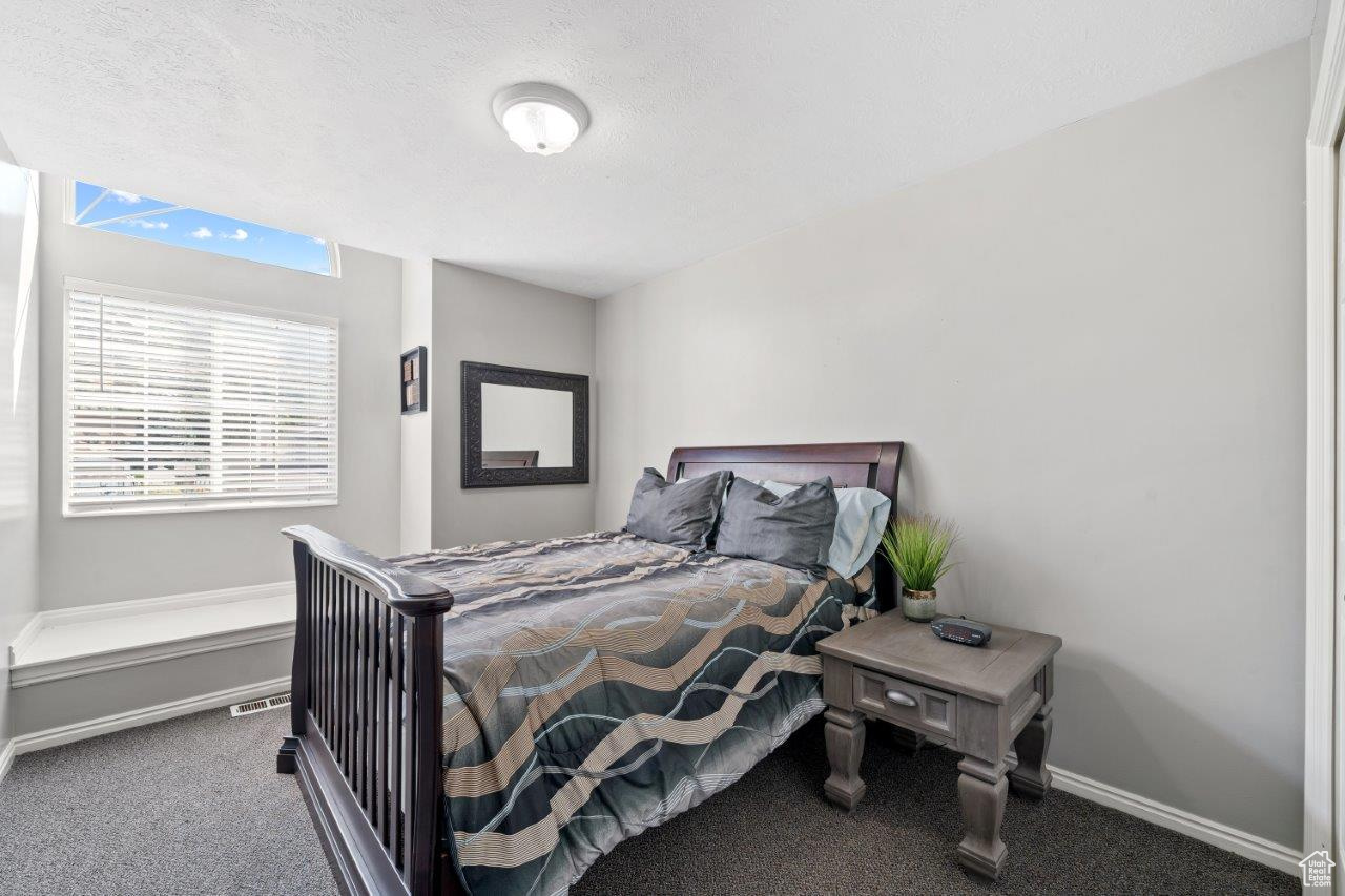 Bedroom featuring a textured ceiling and carpet flooring