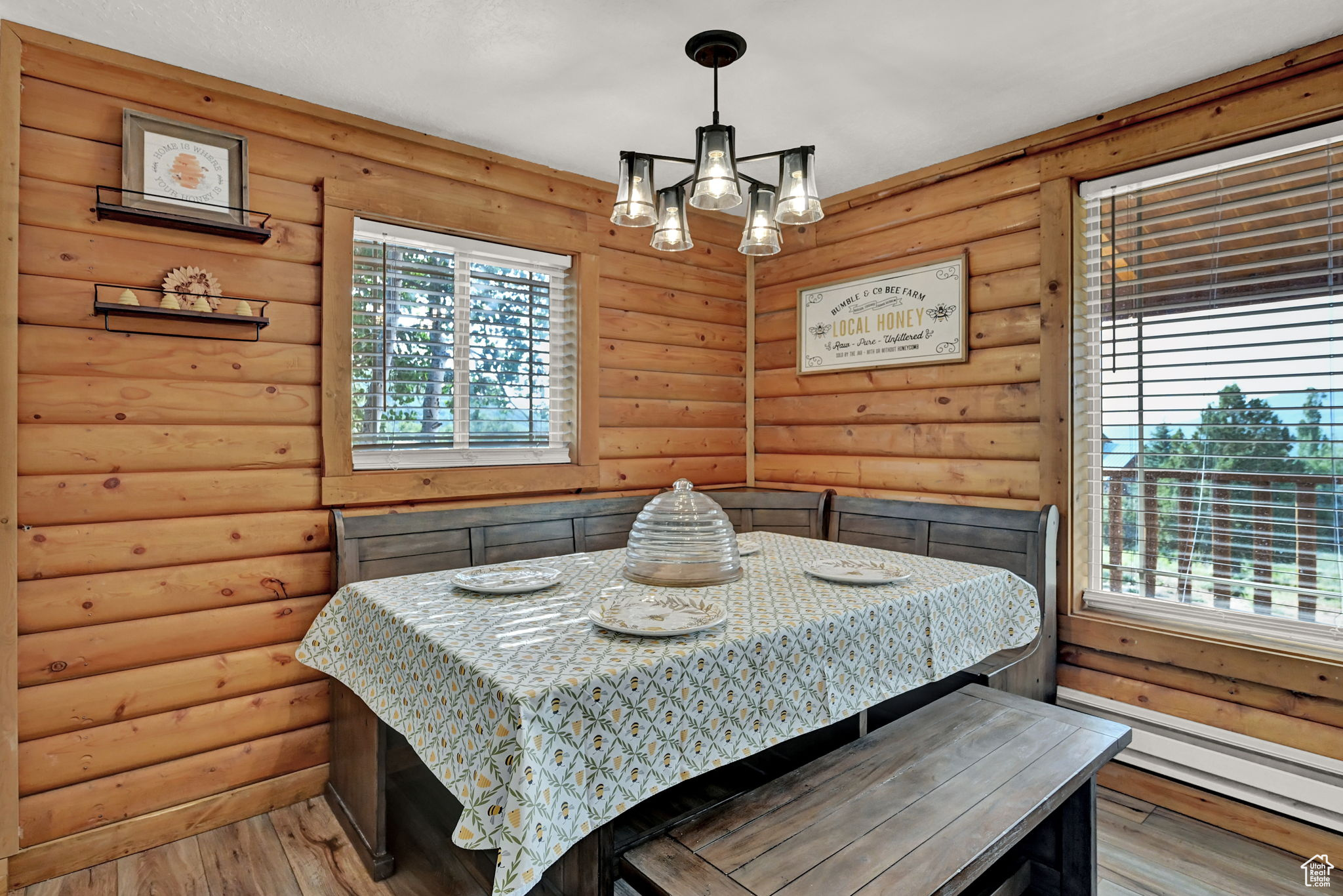 Bedroom featuring light hardwood / wood-style flooring, multiple windows, and log walls