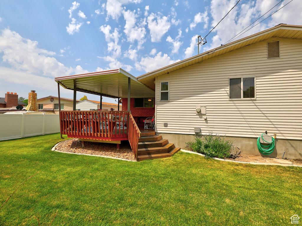 Back of property featuring a deck and a yard