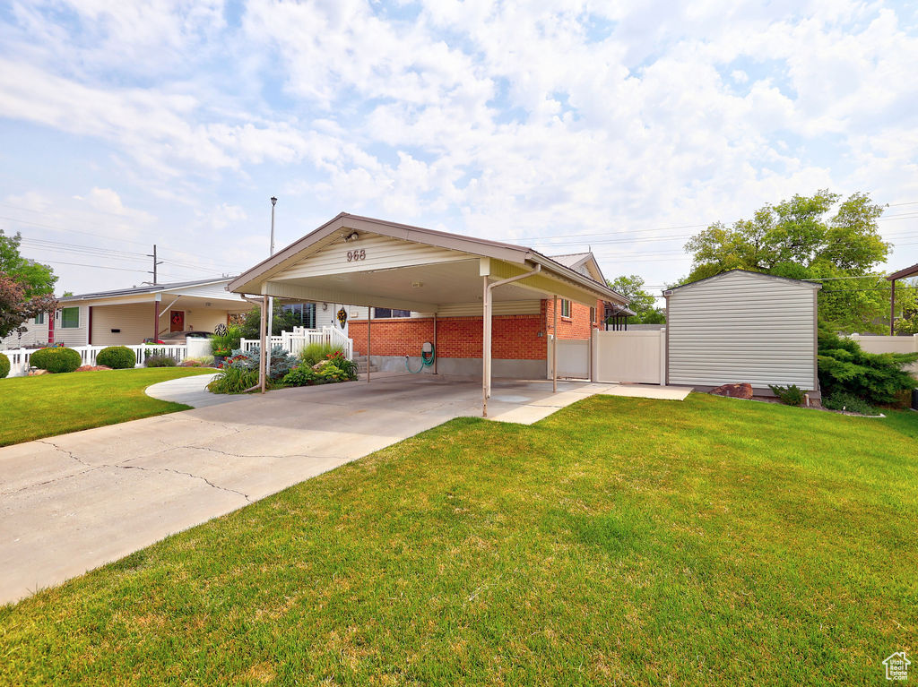 View of front of property featuring a carport and a front yard