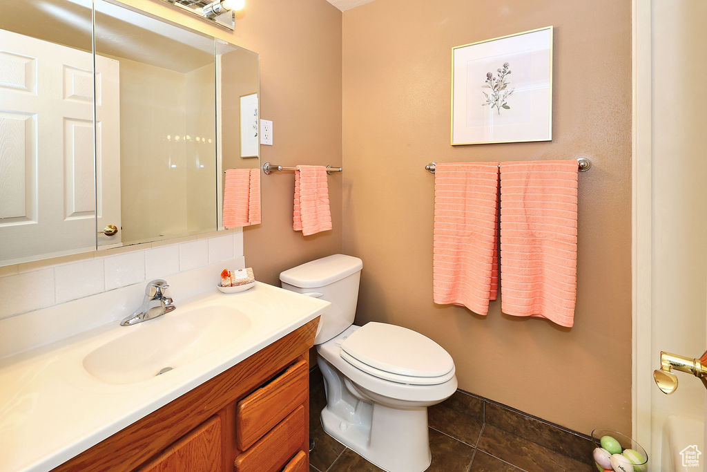 Bathroom featuring vanity, tile patterned floors, decorative backsplash,