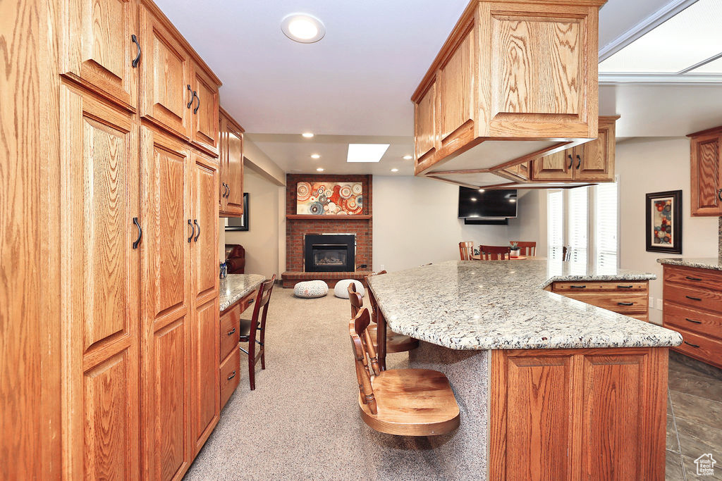 Kitchen featuring a center island, a brick fireplace, and a kitchen breakfast bar