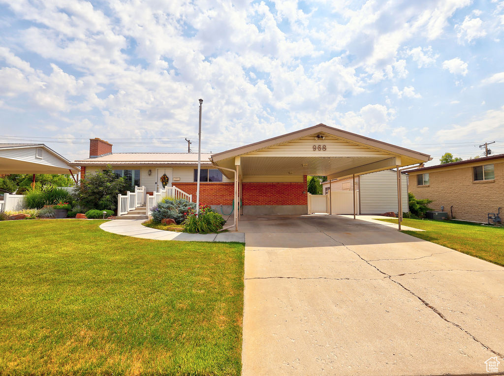 View of front of house featuring a carport and a front yard