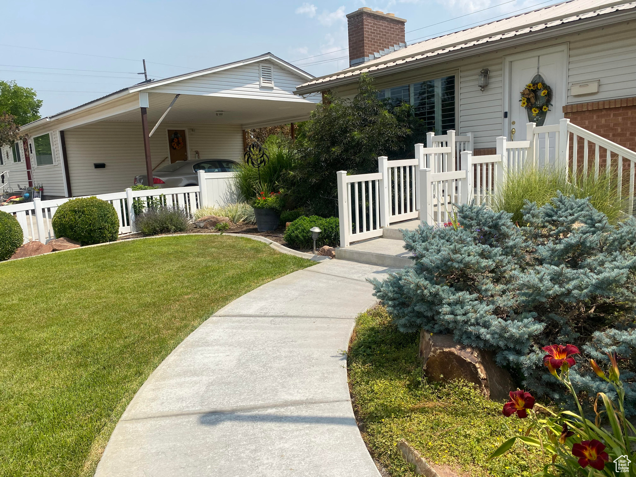 View of front of house with a carport and a front yard