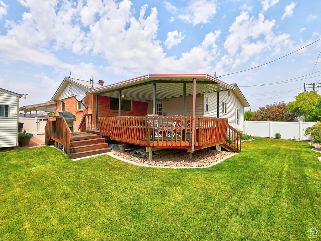 Back of house featuring a deck and a lawn