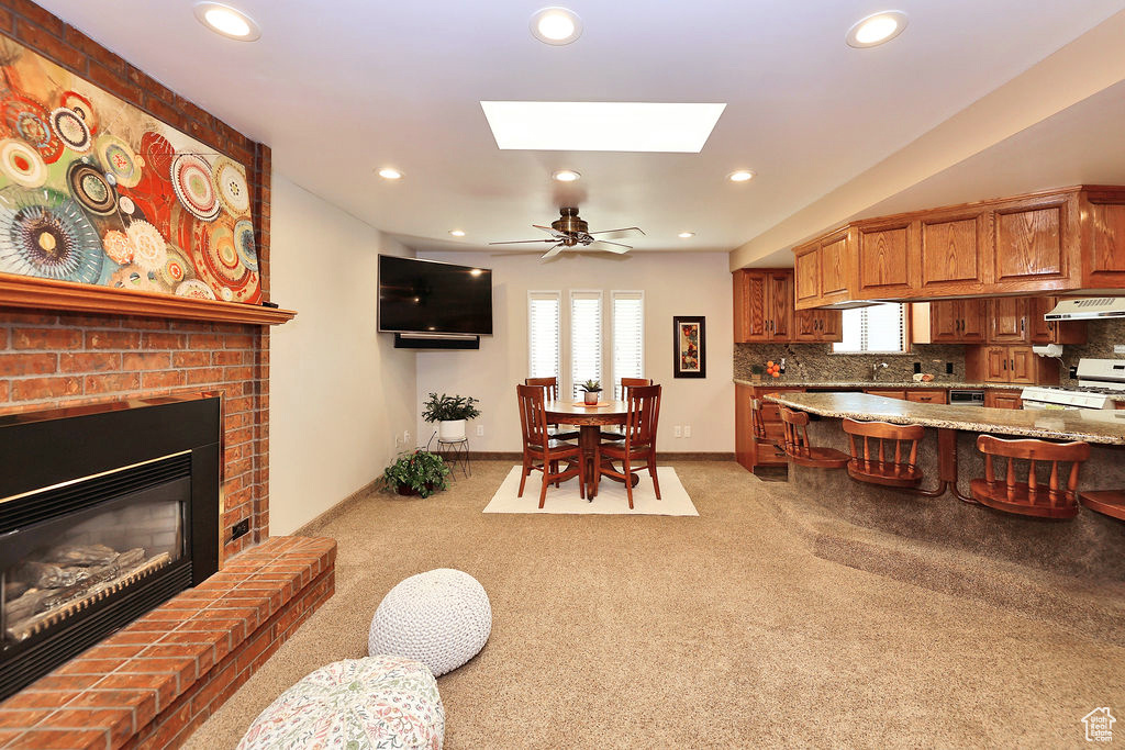 Kitchen featuring a fireplace, backsplash, and a skylight