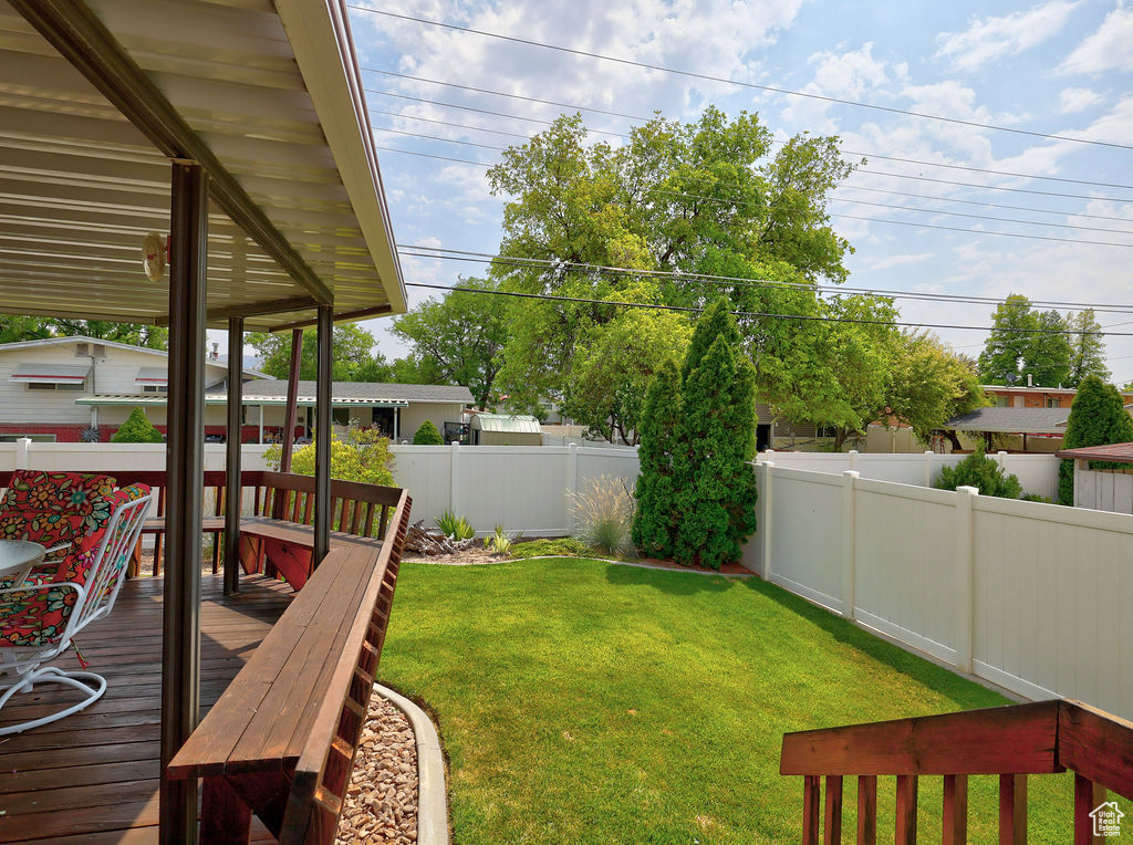 View of yard with a wooden deck and built in seating