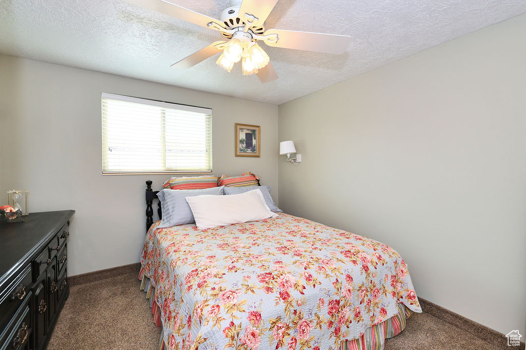 2nd bedroom featuring a textured ceiling and ceiling fan