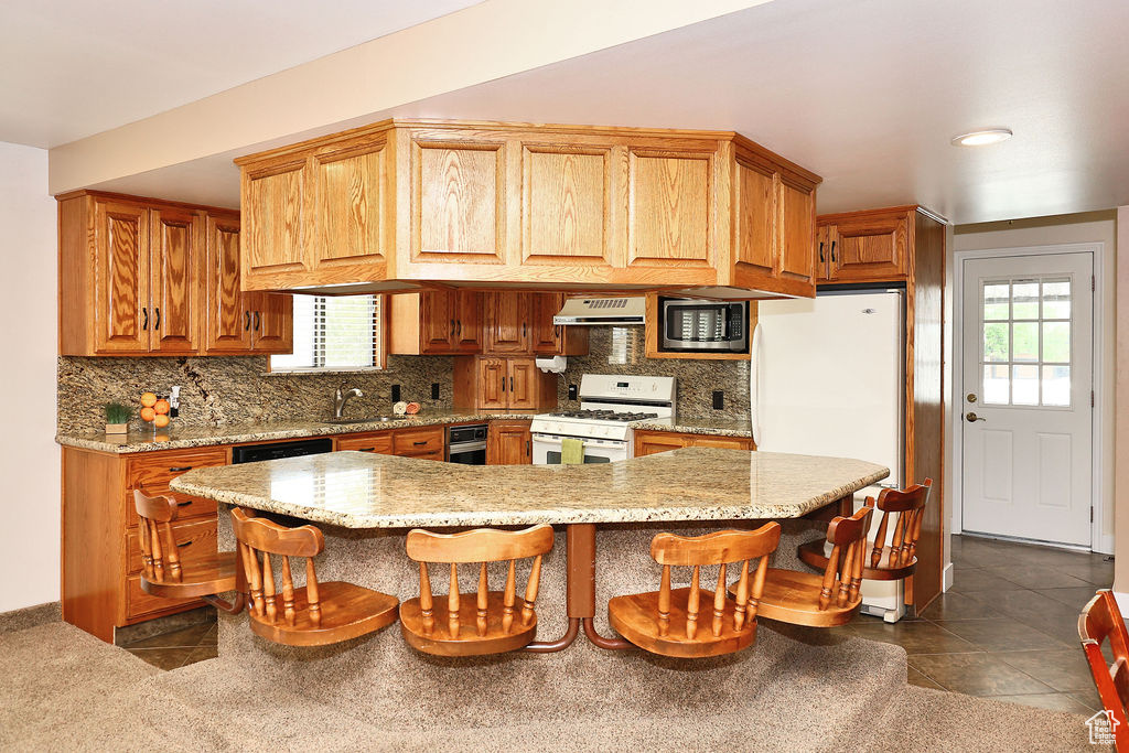 Kitchen with stainless steel microwave, tasteful backsplash, dark tile patterned flooring