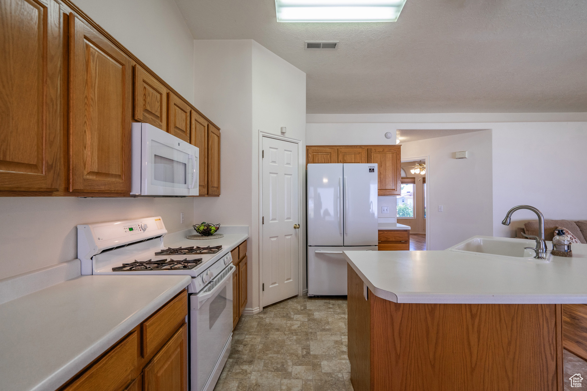 Kitchen featuring center island, sink, and white appliances