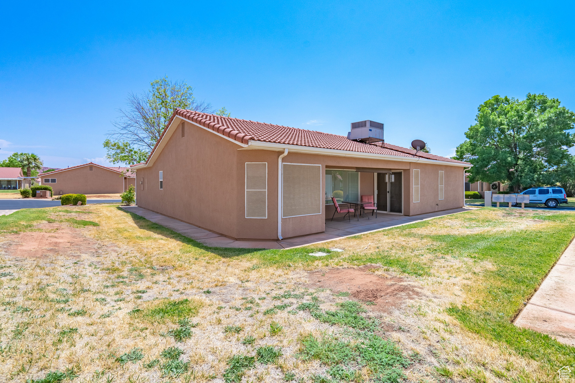 Back of property with a patio and a lawn